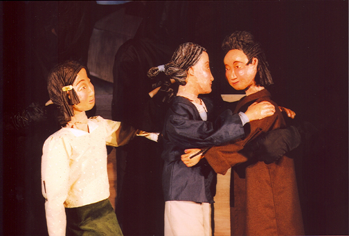 Photo of puppets Tsuki and Momma hugging Lizzy..