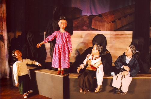 Photo of puppets from The Pink Dress show.  Lizzy showing her pink dress to the family in camp.aling her pink dress to the family in camp.